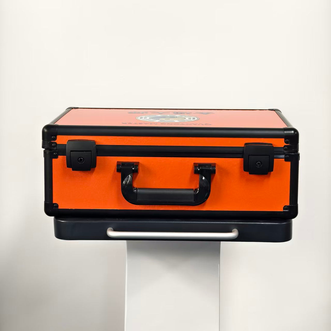 Front view of the closed orange carry case: black handle and two latches